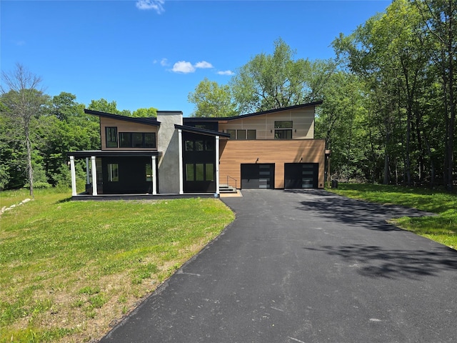 30 Coleman Dr, Campbell Hall, NY 10916 - contemporary house featuring asphalt driveway, a balcony, an attached garage, and a front yard