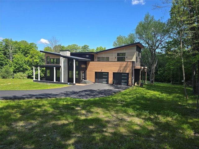 30 Coleman Dr, Campbell Hall, NY 10916 - modern home with an attached garage, asphalt driveway, a front lawn, a chimney, and a balcony