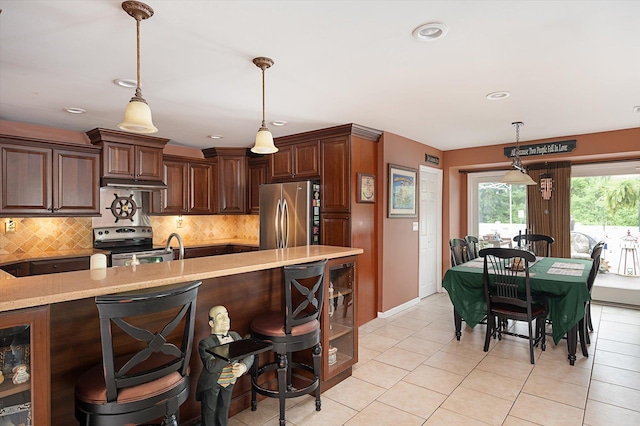 1 Angelica Ct, West Babylon, NY 11704 - kitchen with appliances with stainless steel finishes, tasteful backsplash, hanging light fixtures, light tile patterned flooring, and a kitchen breakfast bar