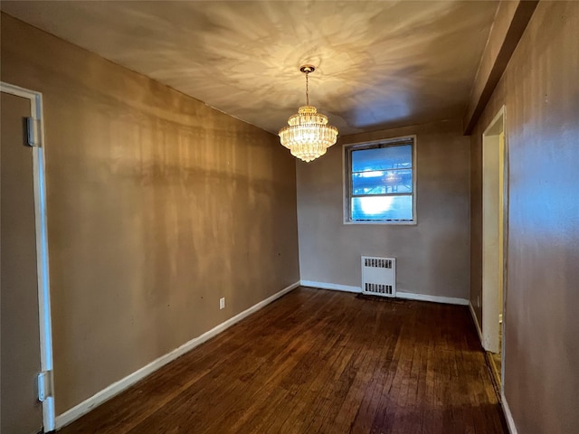 315 King St Unit 2H, Port Chester, NY 10573 - spare room with radiator heating unit, dark wood-type flooring, a chandelier, and baseboards