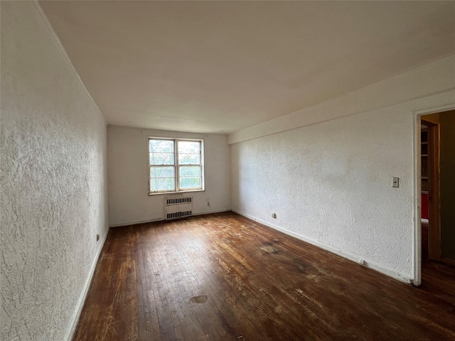 315 King St Unit 2H, Port Chester, NY 10573 - spare room featuring a textured wall, radiator, wood finished floors, and baseboards
