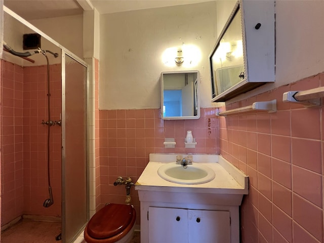 315 King St Unit 2H, Port Chester, NY 10573 - bathroom with a shower stall, tile walls, vanity, toilet, and wainscoting
