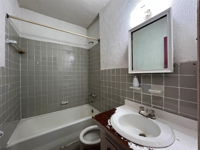 315 King St Unit 2H, Port Chester, NY 10573 - bathroom with vanity, shower / bathtub combination, toilet, tile walls, and a textured wall