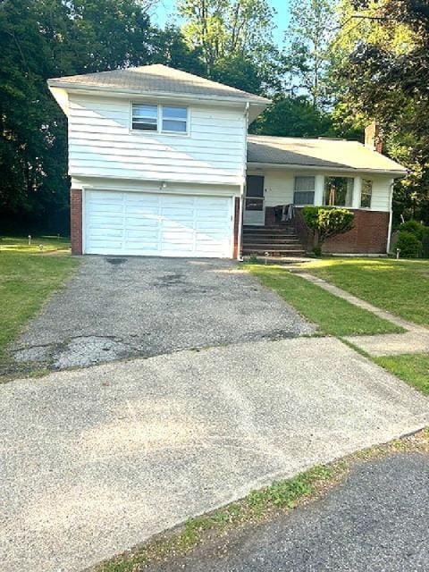 5 Estelle Rd, Poughkeepsie, NY 12601 - split level home featuring an attached garage, a front lawn, driveway, and brick siding