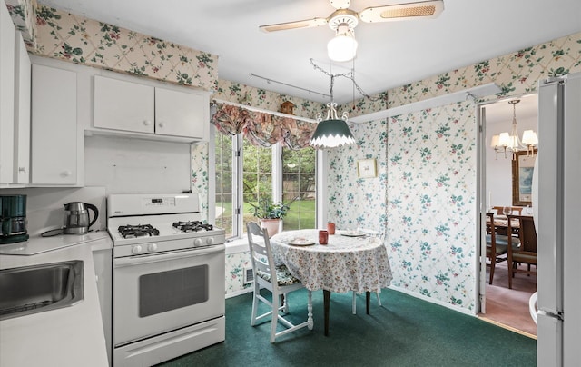 9 Gull Dr, Hauppauge, NY 11788 - kitchen featuring white appliances, wallpapered walls, a chandelier, white cabinets, and light countertops