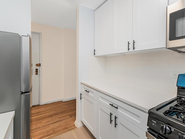 3311 Giles Pl Unit 5H, Bronx, NY 10463 - kitchen with stainless steel appliances, light wood-type flooring, white cabinets, and light countertops