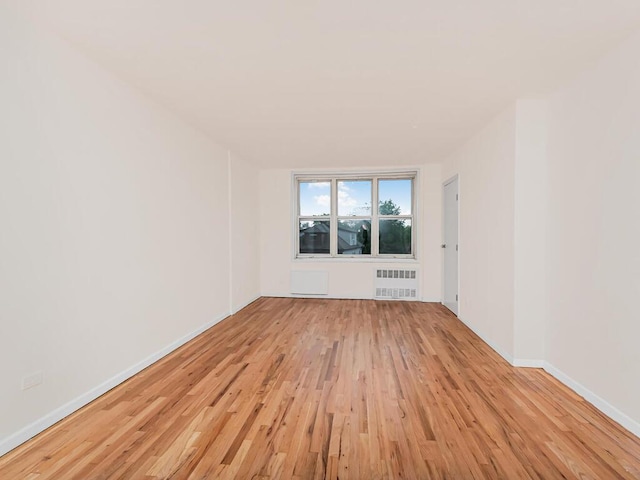3311 Giles Pl Unit 5H, Bronx, NY 10463 - empty room featuring radiator heating unit, light wood-style floors, and baseboards