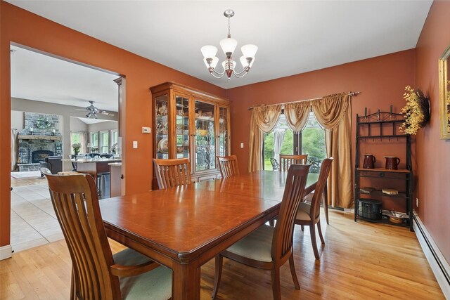 7 Gabriels Dr, Chester, NY 10918 - dining area with a baseboard heating unit, a chandelier, light wood-type flooring, a fireplace, and a ceiling fan