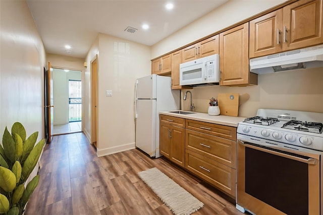 1149 E 219th St, Bronx, NY 10469 - kitchen with white appliances, under cabinet range hood, wood finished floors, light countertops, and recessed lighting