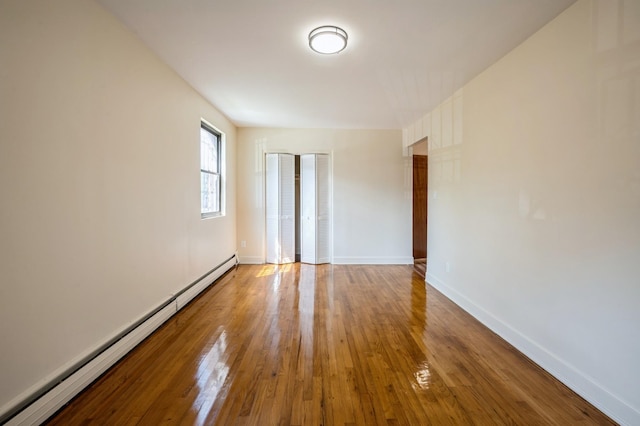 1149 E 219th St, Bronx, NY 10469 - spare room featuring baseboard heating and wood finished floors