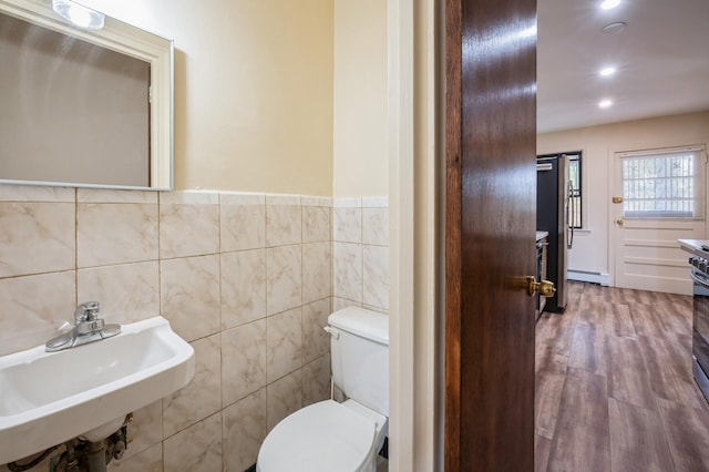 1149 E 219th St, Bronx, NY 10469 - bathroom featuring tile walls, a baseboard heating unit, wood finished floors, recessed lighting, and wainscoting