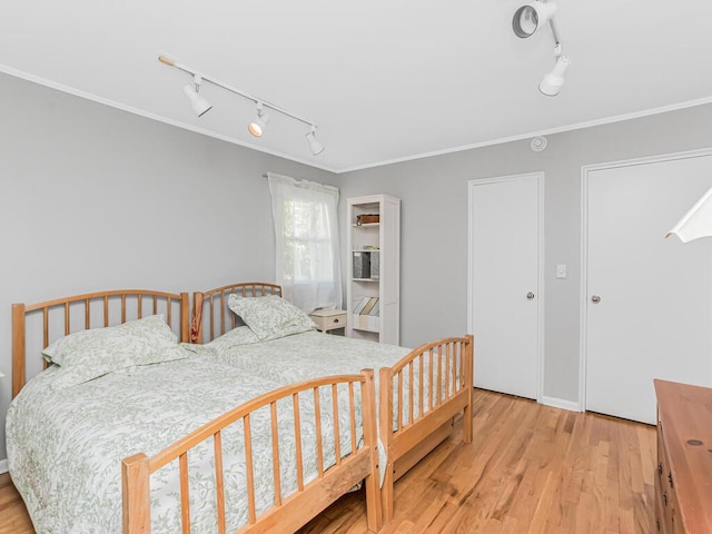 81 Winding Brook Rd, New Rochelle, NY 10804 - bedroom with rail lighting, light wood finished floors, and ornamental molding