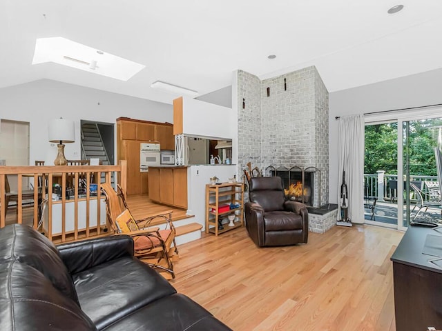 81 Winding Brook Rd, New Rochelle, NY 10804 - living room with a skylight, light wood-style floors, a brick fireplace, and vaulted ceiling