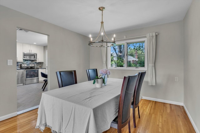 16 Clearland Rd, Syosset, NY 11791 - dining space featuring a chandelier, baseboards, and light wood-style flooring