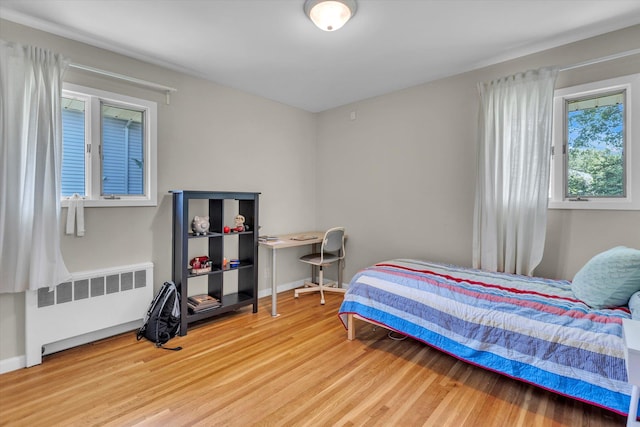 16 Clearland Rd, Syosset, NY 11791 - bedroom with radiator heating unit, wood finished floors, and baseboards