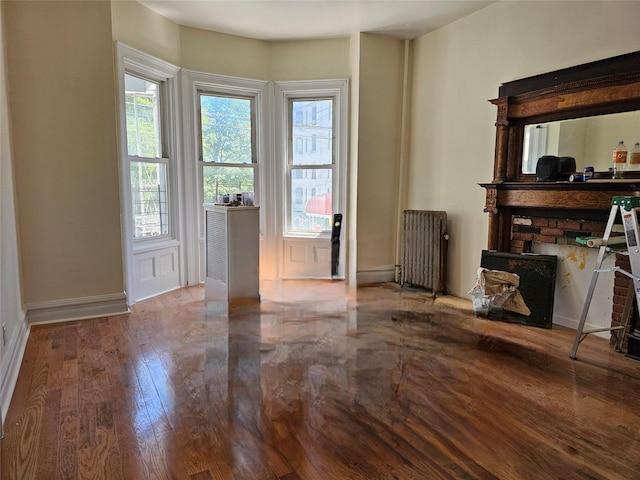 2675 Marion Ave, Bronx, NY 10458 - living area featuring radiator heating unit, wood finished floors, and baseboards