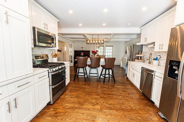 31 Heminway Ave, New Rochelle, NY 10801 - kitchen with appliances with stainless steel finishes, open floor plan, dark wood-type flooring, decorative backsplash, and white cabinets
