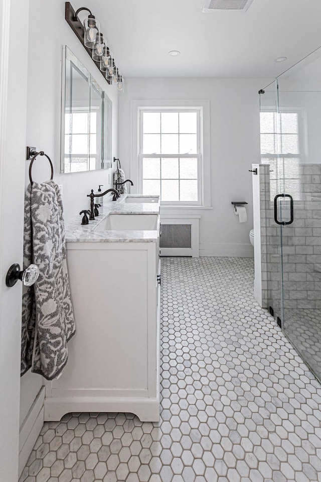 31 Heminway Ave, New Rochelle, NY 10801 - full bathroom with double vanity, toilet, a stall shower, and baseboards