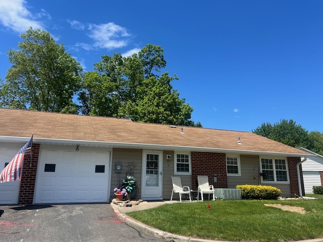 75A Enfield Ct Unit 75A, Ridge, NY 11961 - ranch-style home with a garage, a front lawn, central AC unit, and asphalt driveway