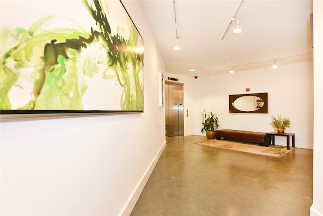 70 S Main St Unit 307-Ph, Freeport, NY 11520 - hall featuring elevator, track lighting, concrete flooring, and baseboards