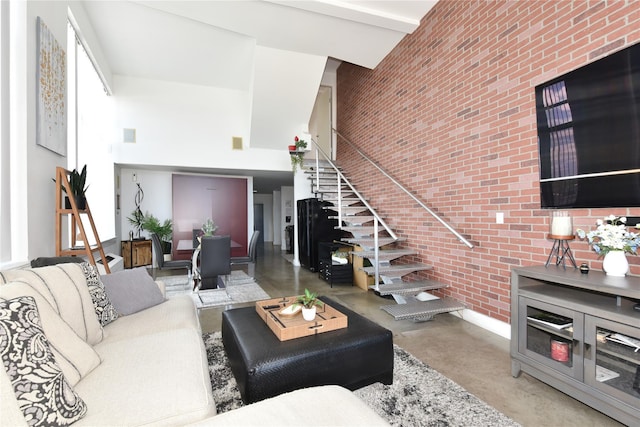 70 S Main St Unit 307-Ph, Freeport, NY 11520 - living room with a high ceiling, concrete flooring, brick wall, and stairway