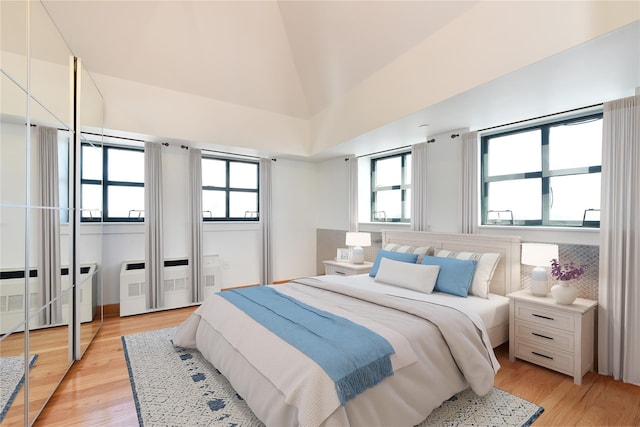 70 S Main St Unit 307-Ph, Freeport, NY 11520 - bedroom featuring radiator heating unit, light wood finished floors, and lofted ceiling