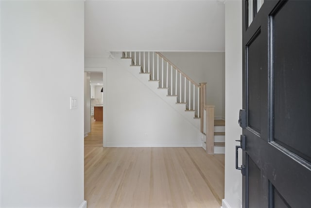 2 Crawford Rd, Harrison, NY 10528 - foyer entrance with light wood finished floors, stairway, and baseboards