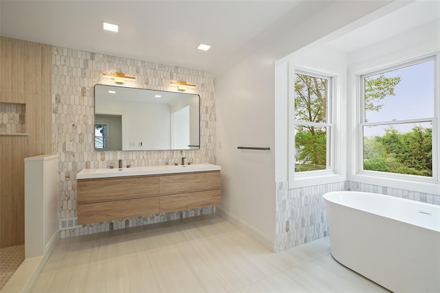 2 Crawford Rd, Harrison, NY 10528 - bathroom with tile walls, double vanity, a freestanding tub, and baseboards