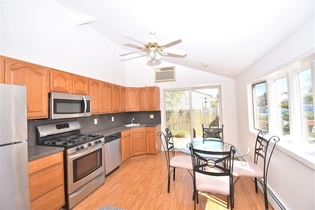 324 W 16th St, Deer Park, NY 11729 - kitchen featuring stainless steel appliances, vaulted ceiling, decorative backsplash, dark countertops, and light wood finished floors