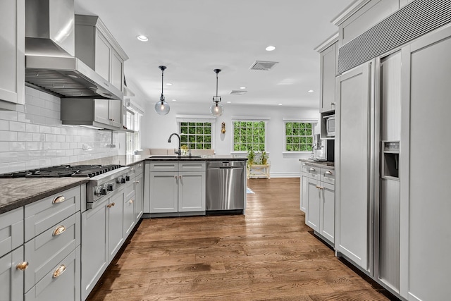 9 Springdale Rd, Scarsdale, NY 10583 - kitchen featuring stainless steel appliances, wall chimney range hood, a sink, a peninsula, and recessed lighting
