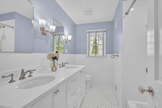 9 Springdale Rd, Scarsdale, NY 10583 - bathroom with toilet, double vanity, wainscoting, tile walls, and shower / washtub combination