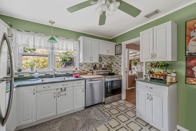 891 Pondview Rd, Riverhead, NY 11901 - kitchen with appliances with stainless steel finishes, white cabinetry, light floors, plenty of natural light, and crown molding