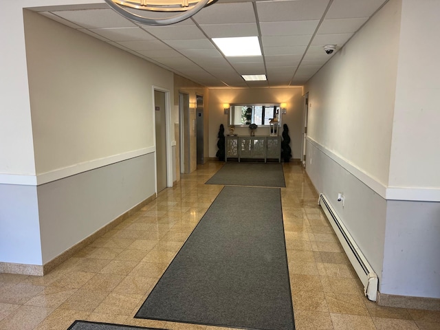 101 Jackson Ave Unit 4A, Mineola, NY 11501 - corridor with a baseboard heating unit, a paneled ceiling, and baseboards