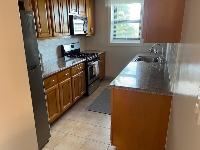 101 Jackson Ave Unit 4A, Mineola, NY 11501 - kitchen featuring stainless steel gas range, black microwave, a sink, light tile patterned floors, and backsplash