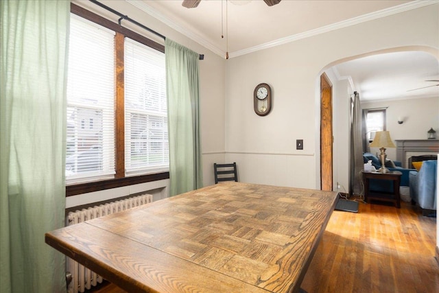 139 Euston Rd S, West Hempstead, NY 11552 - dining room featuring a ceiling fan, arched walkways, crown molding, hardwood / wood-style floors, and healthy amount of natural light