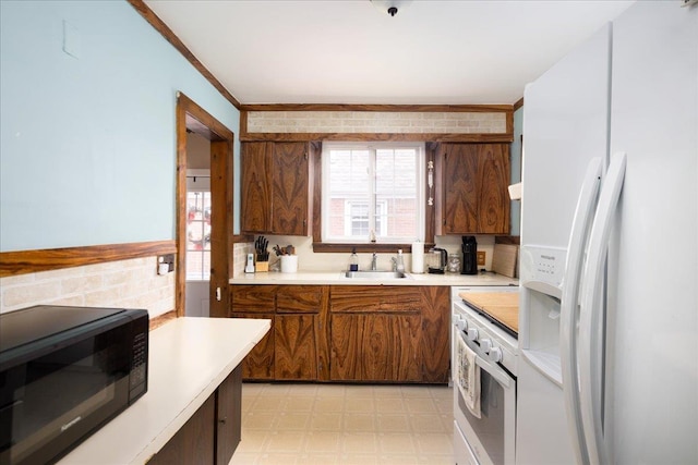 139 Euston Rd S, West Hempstead, NY 11552 - kitchen with white fridge with ice dispenser, black microwave, light floors, light countertops, and oven