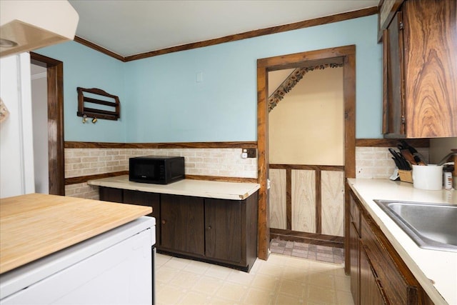 139 Euston Rd S, West Hempstead, NY 11552 - kitchen featuring black microwave, light flooring, light countertops, wainscoting, and a sink