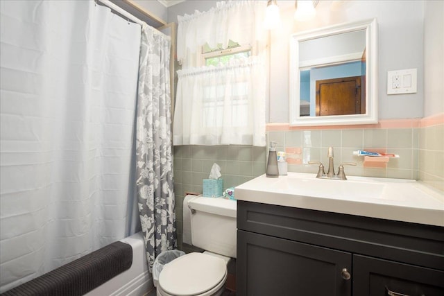 139 Euston Rd S, West Hempstead, NY 11552 - bathroom featuring tile walls, vanity, toilet, and shower / bathtub combination with curtain
