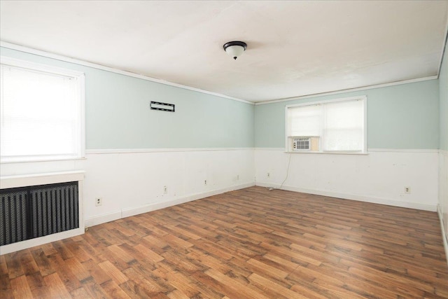 139 Euston Rd S, West Hempstead, NY 11552 - spare room with radiator, wood finished floors, crown molding, and a wainscoted wall