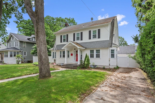 177 N Long Beach Ave, Freeport, NY 11520 - dutch colonial featuring a gate, driveway, a chimney, a front yard, and a shingled roof