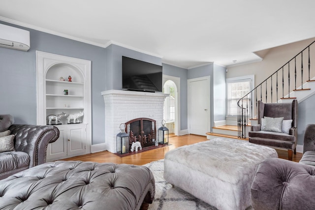 177 N Long Beach Ave, Freeport, NY 11520 - living room featuring stairway, light wood-style flooring, a brick fireplace, built in shelves, and ornamental molding