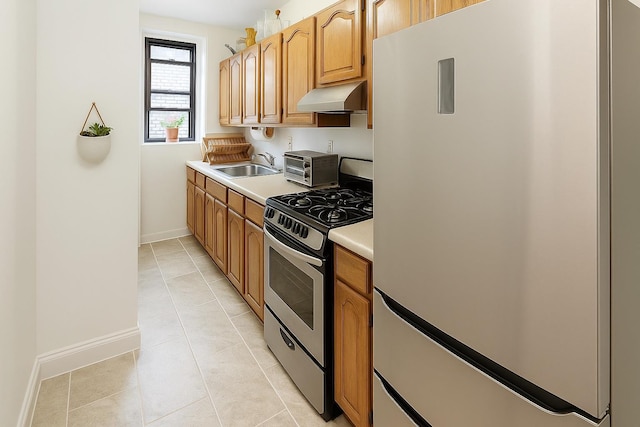 68 E Hartsdale Ave Unit 5E, Hartsdale, NY 10530 - kitchen with freestanding refrigerator, stainless steel range with gas stovetop, under cabinet range hood, a sink, and baseboards