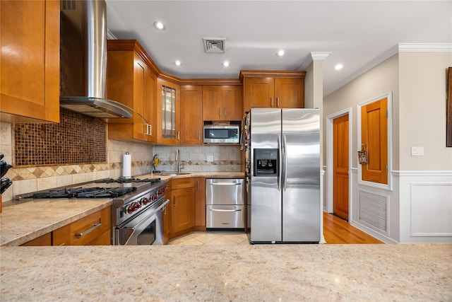 154-16 13th Ave, Whitestone, NY 11357 - kitchen featuring stainless steel appliances, wall chimney range hood, brown cabinetry, a sink, and ornamental molding