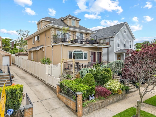 154-16 13th Ave, Whitestone, NY 11357 - view of front of property with a balcony, stucco siding, concrete driveway, a garage, and a gate