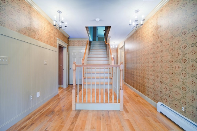 231 Turtle Bay Rd, New Hampton, NY 10958 - stairs featuring a chandelier, wallpapered walls, a baseboard heating unit, wood finished floors, and crown molding
