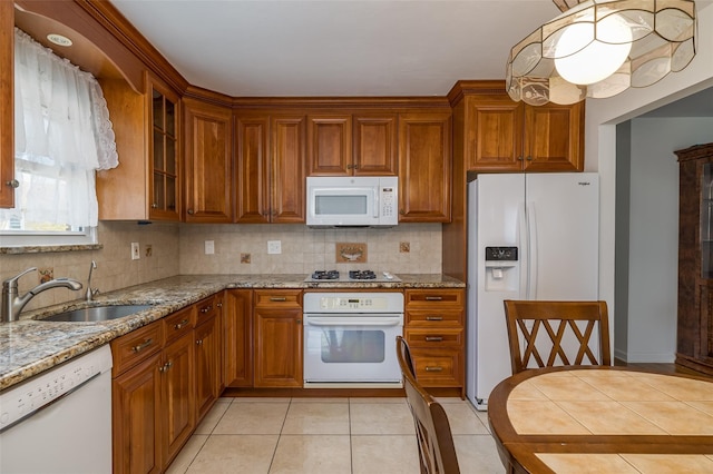 563 Long Beach Rd, Island Park, NY 11558 - kitchen with white appliances, a sink, brown cabinets, and light stone counters