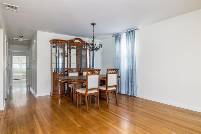 563 Long Beach Rd, Island Park, NY 11558 - dining space featuring a chandelier, wood finished floors, and baseboards