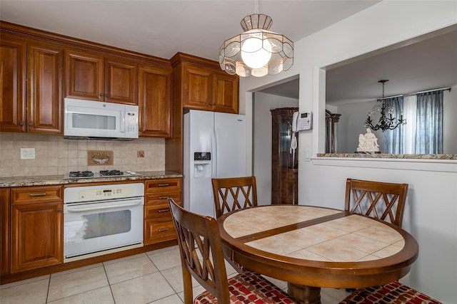 563 Long Beach Rd, Island Park, NY 11558 - kitchen with white appliances, a chandelier, brown cabinets, and decorative backsplash