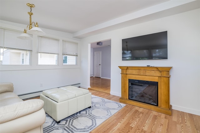 563 Long Beach Rd, Island Park, NY 11558 - living room featuring light wood-style flooring, a baseboard radiator, a glass covered fireplace, and baseboards