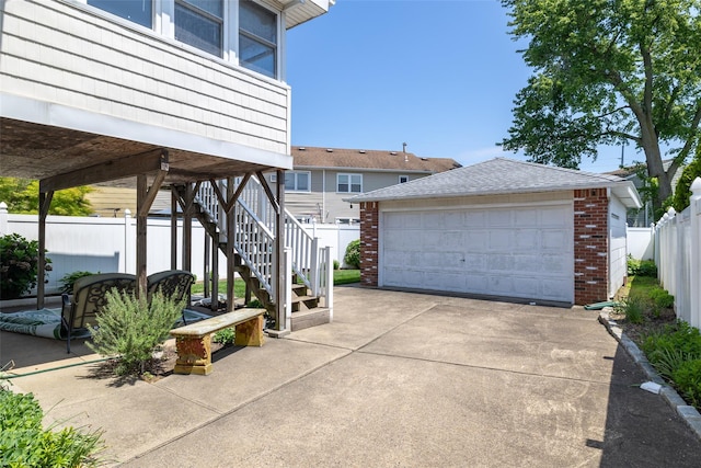 563 Long Beach Rd, Island Park, NY 11558 - view of property exterior with a garage, brick siding, an outbuilding, a shingled roof, and stairs